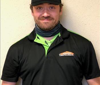 A brown haired male with beard wearing a SERVPRO uniform 