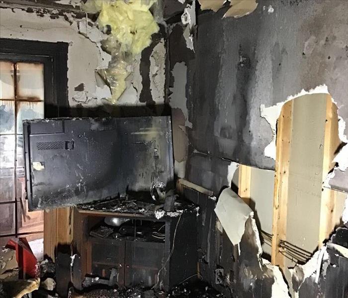Extreme Fire Damage of a family room including burnt, charred and damaged walls along with  