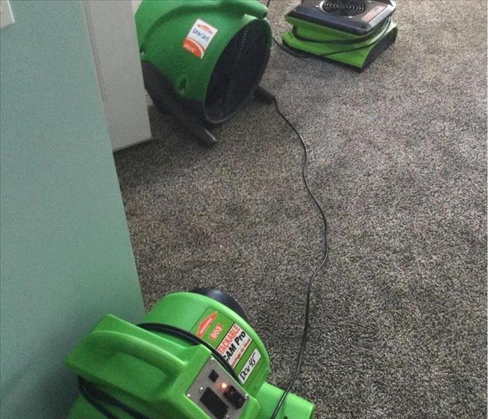 family room with three servpro green air movers used to dry the water damaged space