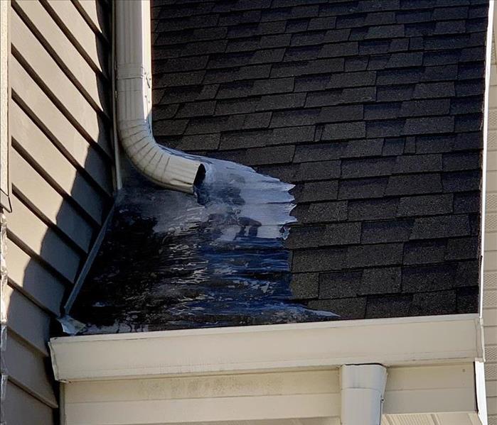 a black shingled roof line with an ice dam that caused water damge