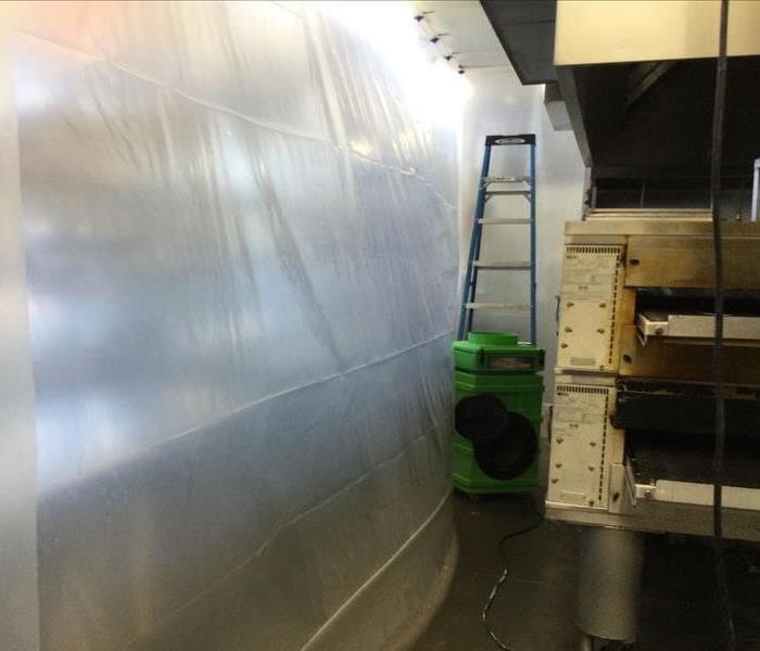 a commercial kitchen with plastic containment set up to reduce drying time 