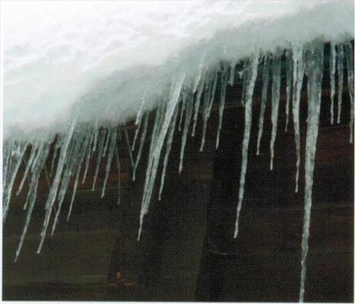 a section of a roof with dripping with water and icicles