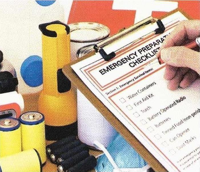an emergency checklist on a clip board with a human hand checking off the items on the list