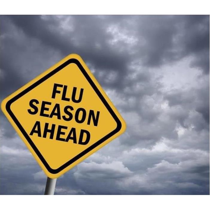 a cloudy backdrop with warning sign saying "Flu Season Ahead"