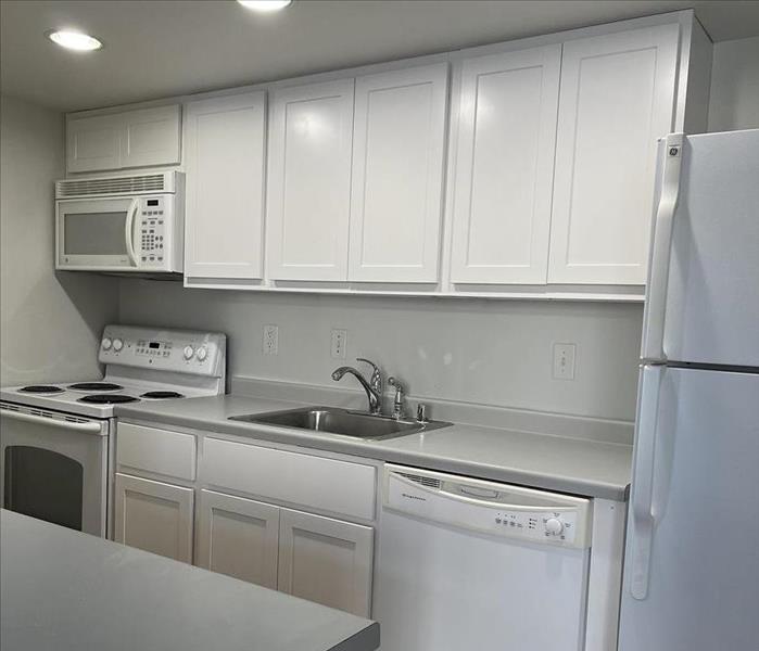 a fully remodeled and restored apartment kitchen after a water damage
